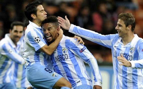 Malaga players celebrate Eliseu goal against Ac Milan