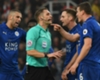 Leicester City players confront referee Craig Pawson