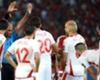 Tunisia's players surround referee Seechurn Rajindrapasard